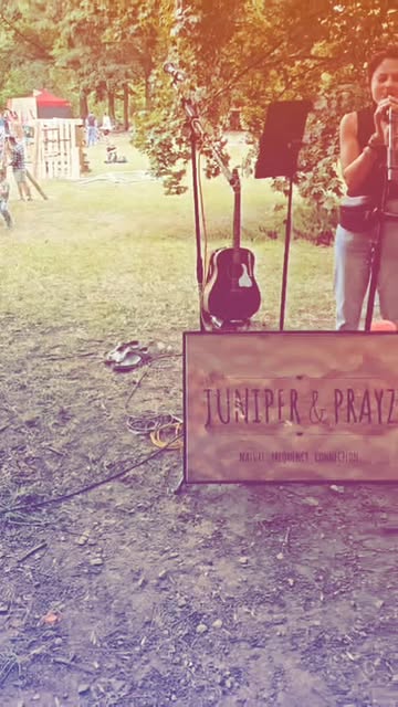 Juniper singing beside a guitar and Juniper and Prayz performance sign at Rudolstadt Festival